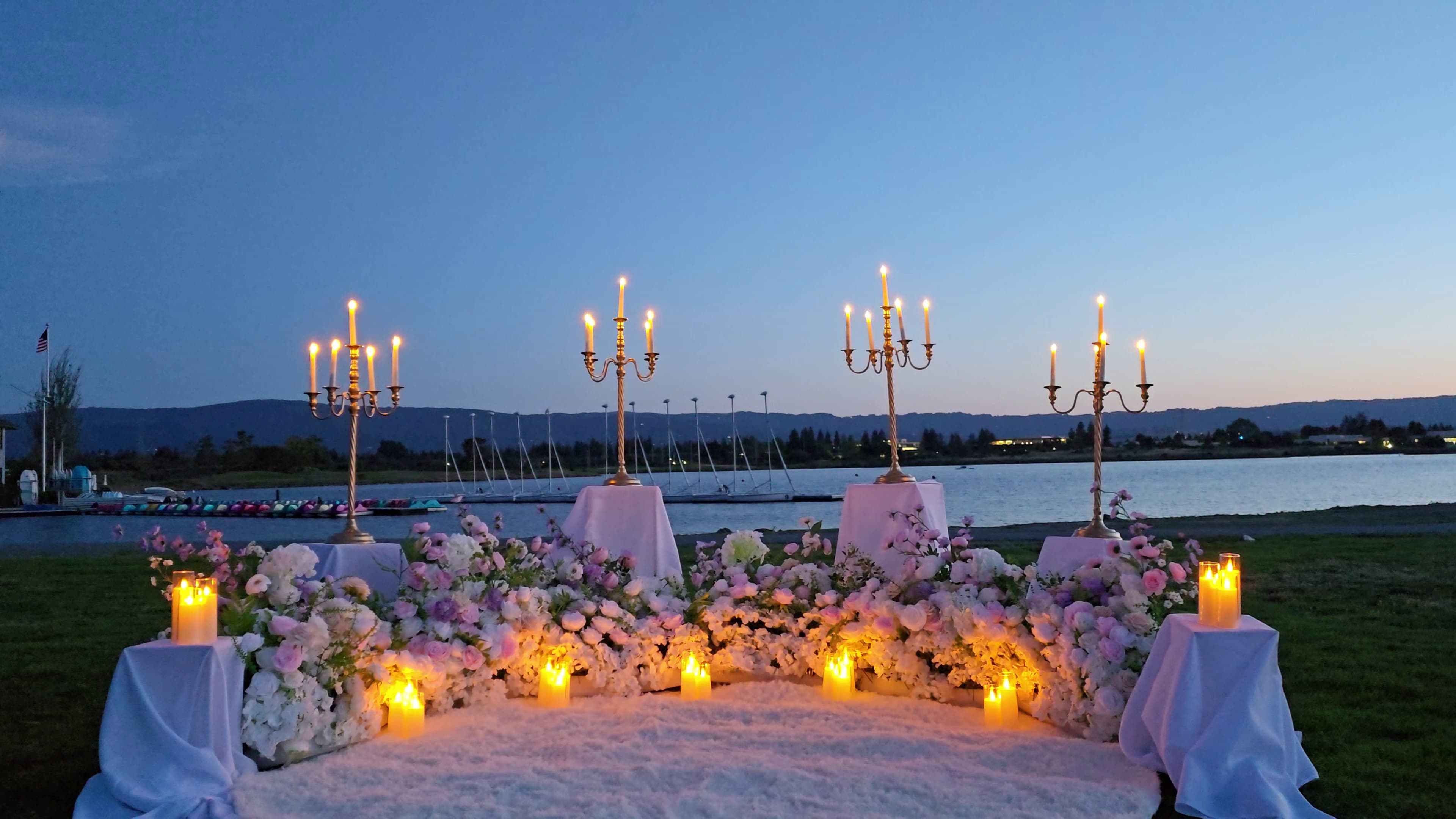 Enchanted Romance proposal setup with gold candelabras and lush floral semicircle
