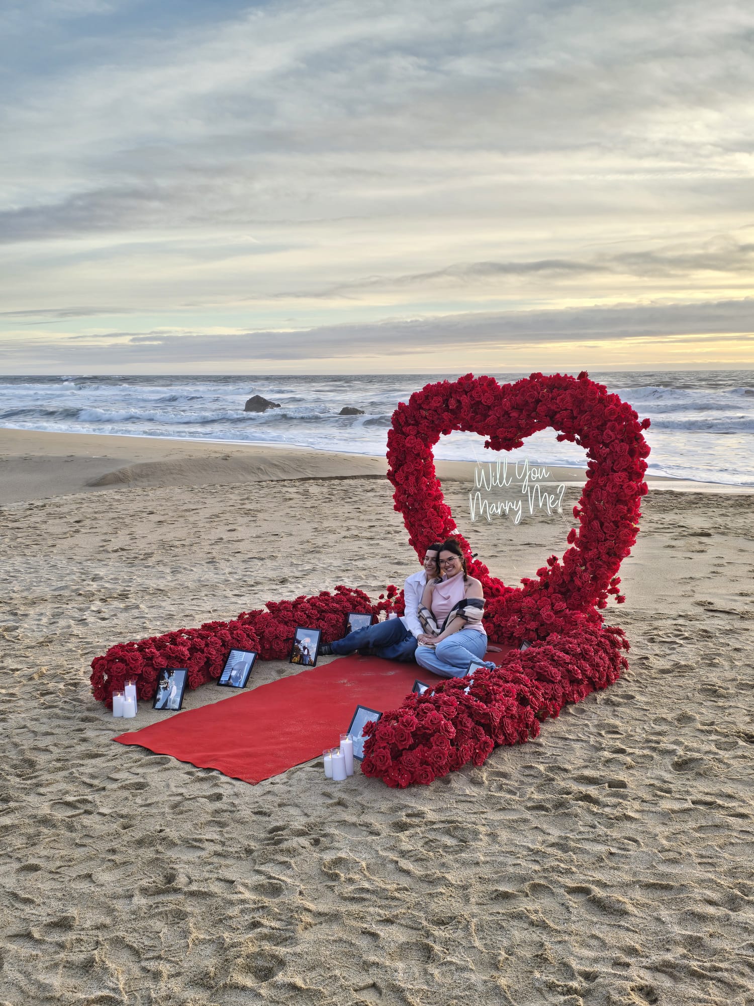 Red heart arch proposal setup on the Memory Walkway at Half Moon Bay State Beach