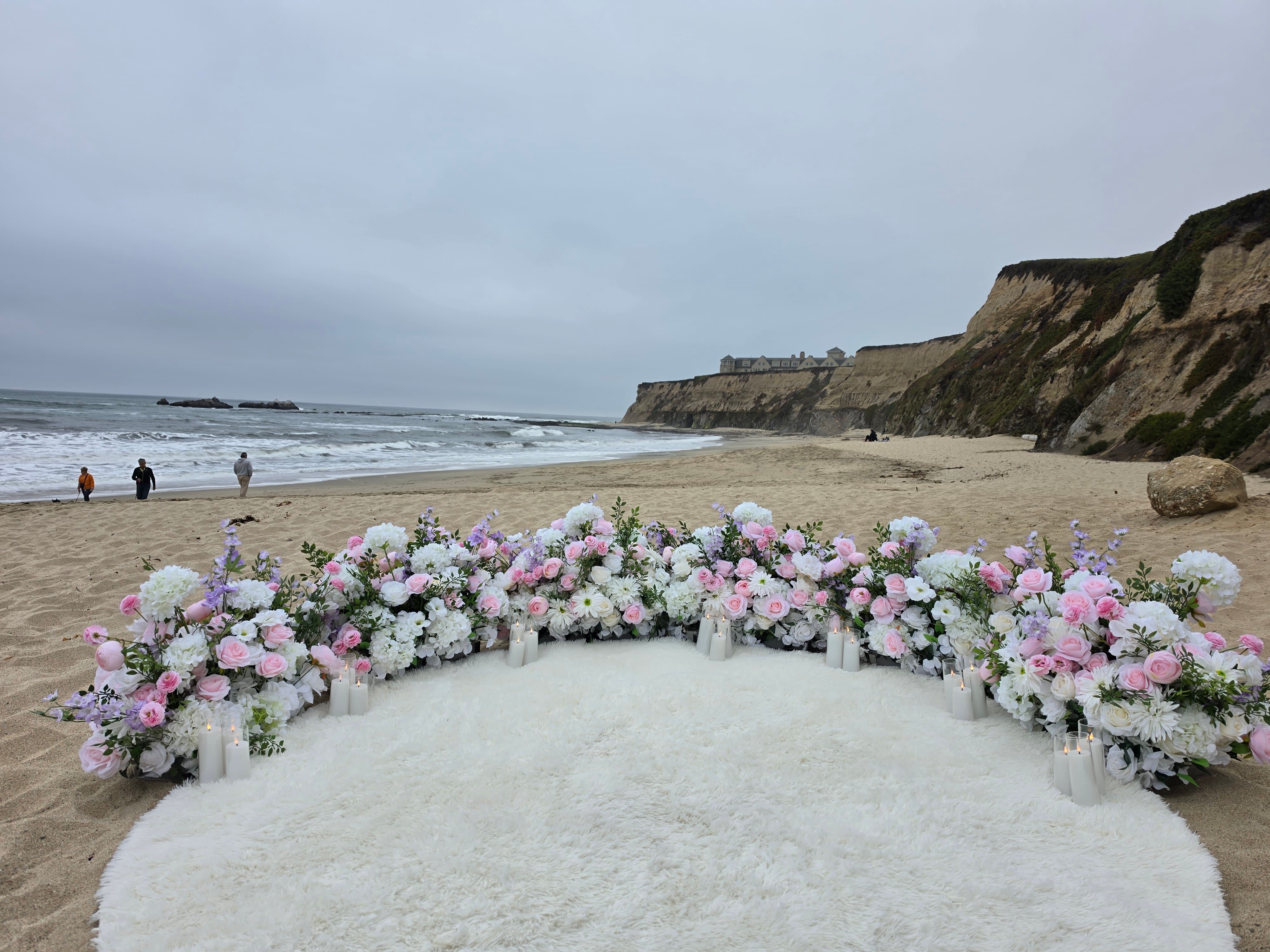 The Intimate Promise – blush pink, white, and lavender grounded florals with a fluffy white rug at Manhattan Beach, Half Moon Bay