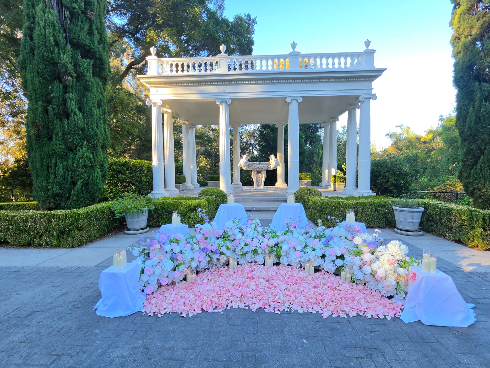 The Love Temple at Montalvo Arts Center framed by cypress trees, with a pink and white floral installation and rose petal aisle