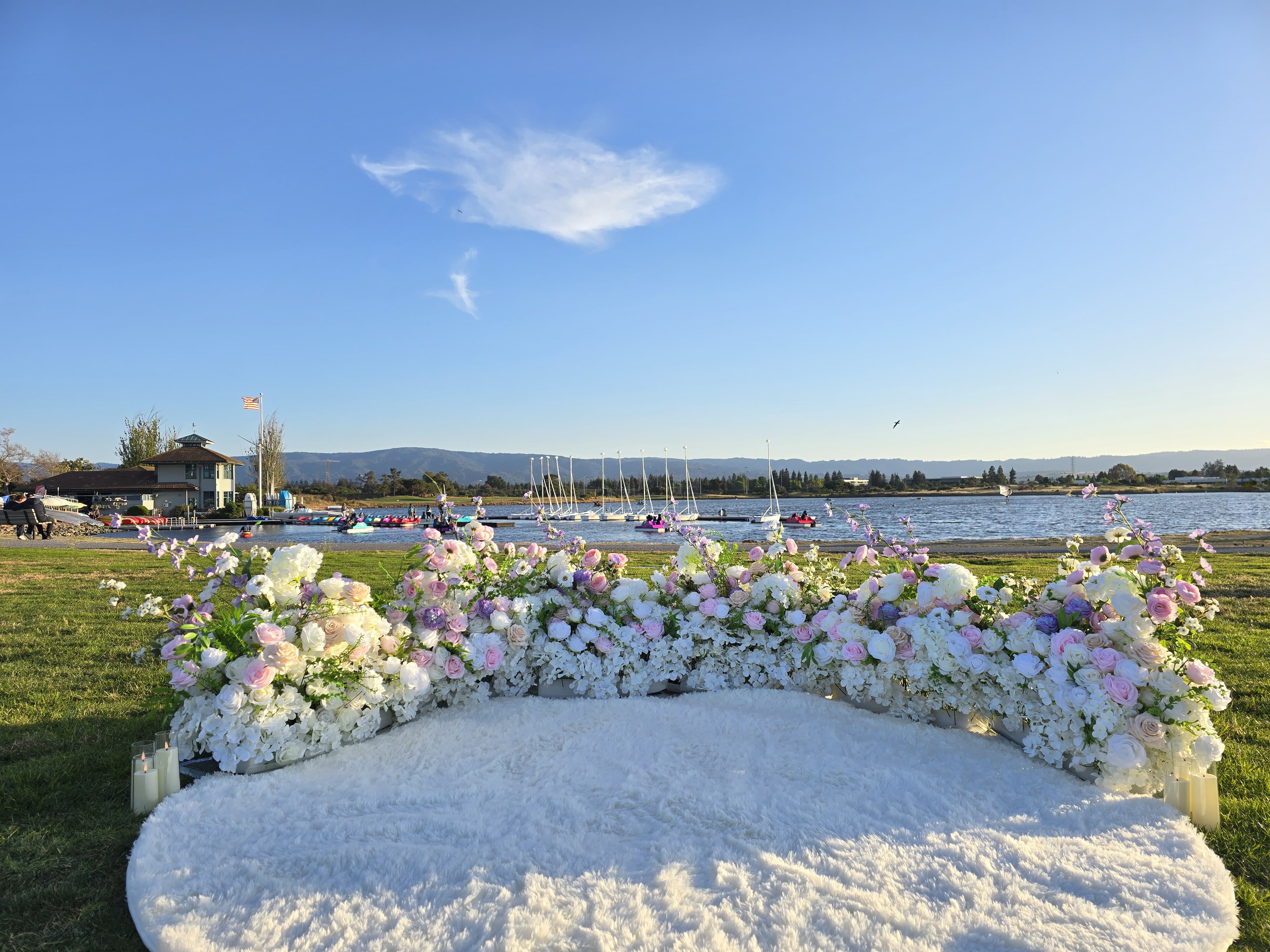 White and pink florals with fluffy white rug proposal setup at Shoreline Park